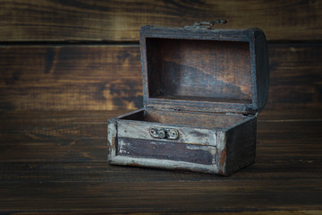 Ancient chest with open lid on wooden background