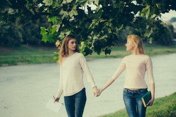 Obraz premium Two young girls hold hands