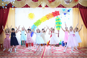 Performance of thirteen young girls at the graduation in the kindergarten
