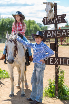 cowboy brother and sister with a signpost