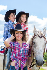 cowboy mother with son and daughter on a horse