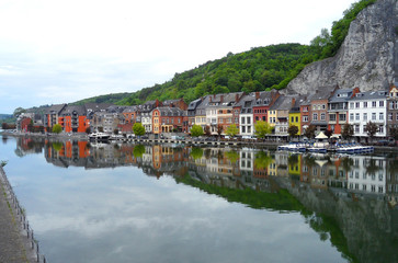 Fototapeta na wymiar The Reflection of Colorful Traditional Architectures on the Meuse River in Dinant, Belgium