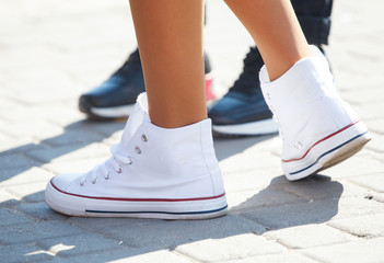 feet of girl in white sneakers, close-up