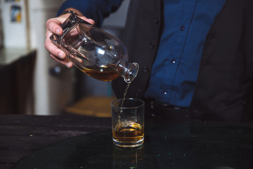 Businessman pouring whiskey in his glass