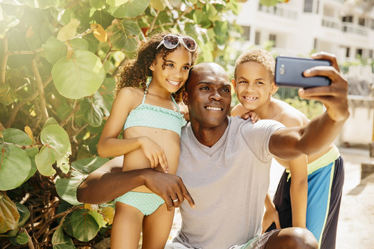 Father and children taking selfie outdoors