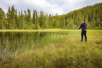 Woman fishing in fresh water creek in the forest