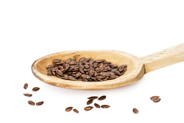 Linseed on a wooden spoon seen from the side on white background