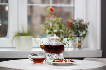 A table in a cafe with brewed tea and waffles with jam