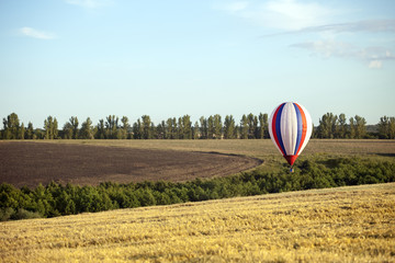 Obraz premium Balloons start fly on fields, hills in summer