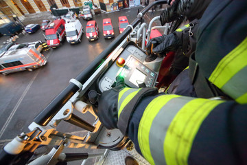 firefighter operates fire truck ladder out of the cradle