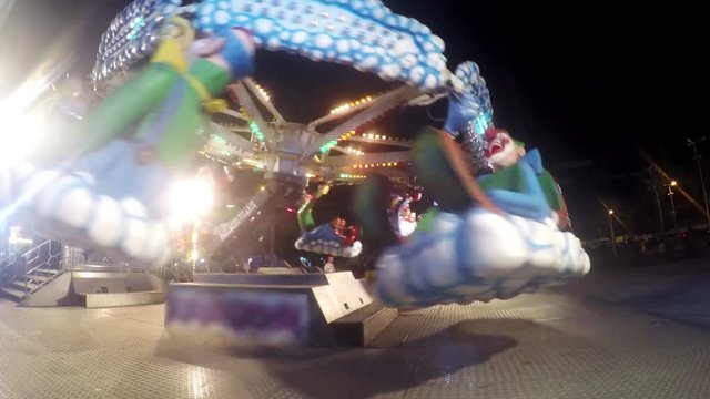 Children enjoy entertainment ride at night in luna park