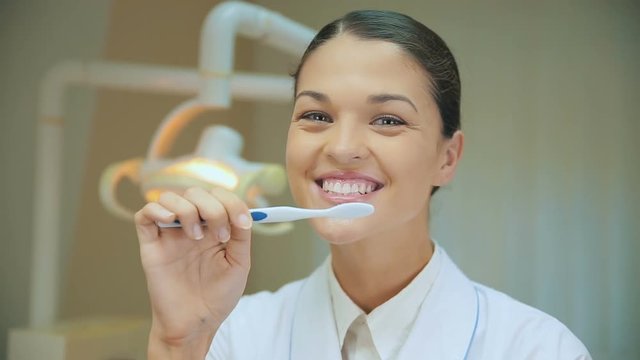 Dentist doctor showing how to to clean teeth