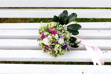 Beautiful bridal bouquet of flowers on wooden bench 