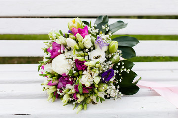 Beautiful bridal bouquet of flowers on wooden bench 