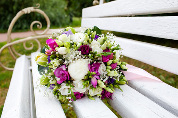 Beautiful bridal bouquet of flowers on wooden bench 