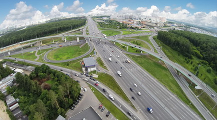 Fototapeta na wymiar Transport traffic on Novorizhskaja flyover and Moscow ring road at summer day. Aerial view. Photo with noise from action camera.