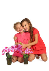 Portrait of two happy girls with orchids in pots isolated on white