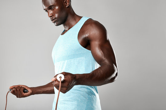 Muscular young man exercising with jumping rope - Powered by Adobe