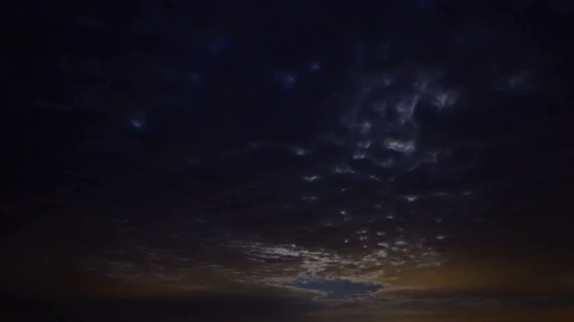 Dark clouds are transforming and moving across the night sky and moon. Time-lapse, UHD - 4K