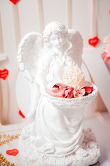 Angel statue with rose petals in hands