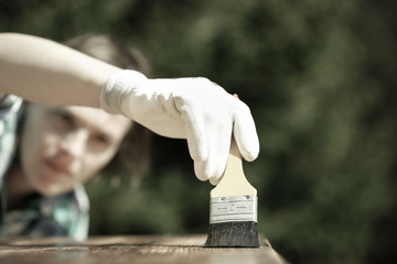 Woman carpenter inspecting freshly painted wood