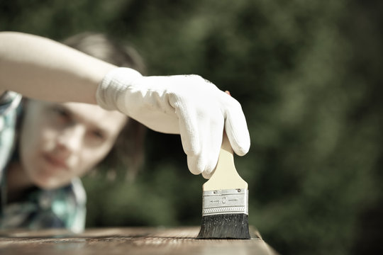 Woman Carpenter Inspecting Freshly Painted Wood