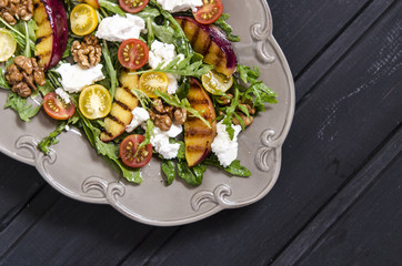 Salad with arugula and cherry tomatoes feta peaches with balsamic cream  