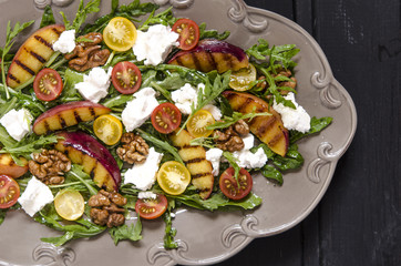 Salad with arugula and cherry tomatoes feta peaches with balsamic cream  