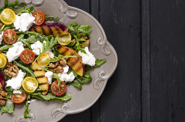Salad with arugula and cherry tomatoes feta peaches with balsamic cream  