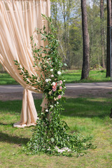 Beige wedding arch decorated with flowers