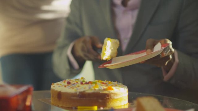 Happy family party - mature man cuts his birthday cake