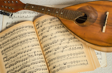 Old mandolin with music notes in the background.