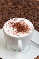 Tasse Cappuccino auf braunen Kaffeebohnen