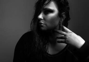 black and white portrait of young woman sitting at home, thinking, contemplation