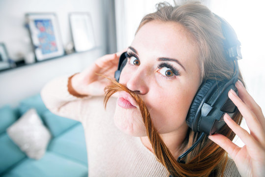 Portrait young woman with headphones listening to music at home