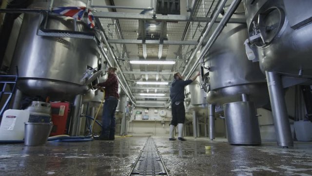  Workers in a brewery cleaning & checking the machines