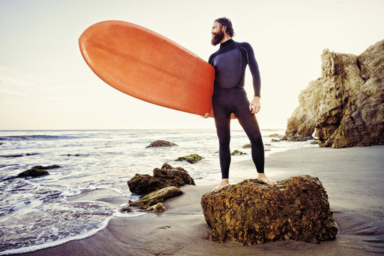 Caucasian man holding surfboard at beach