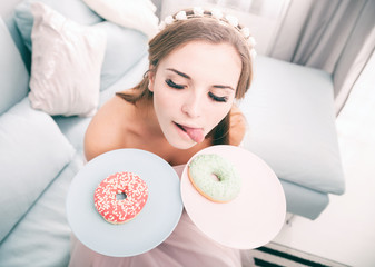 Obraz na płótnie Canvas Woman look like princess at home with two donuts