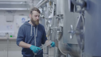  Worker in a brewery testing beer & checking quality of the product