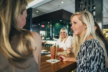 Women sitting at bar with cocktails