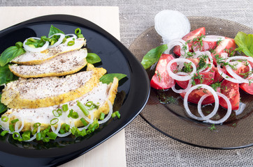 Closeup view on a roasted slices of chicken fillet and salad