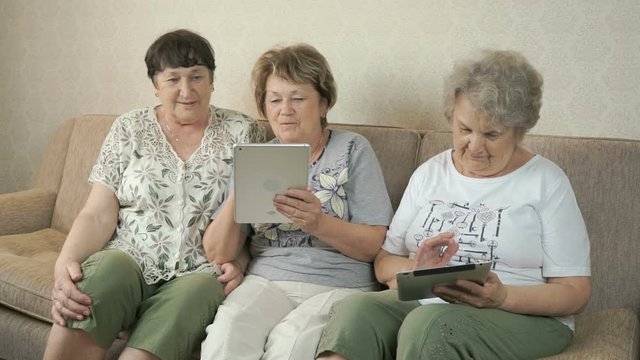 Women holding the silver digital tablets