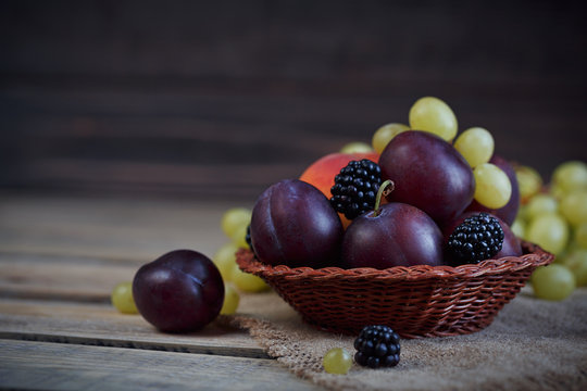 Mix of fresh berries and fruits on rustic wooden background
