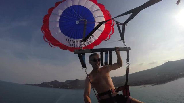 Happy Man Parasailing in Sky on Vacation in Summer
