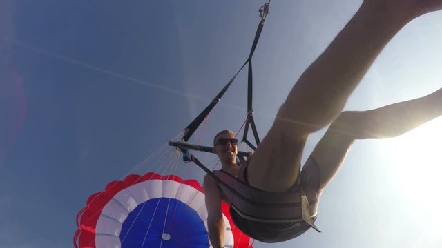 Smiling Tourist Man Parasailing with GoPro over Sea on Holidays