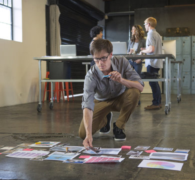 Caucasian businessman examining paperwork on office floor