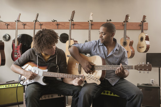 Father And Son Playing Guitars Together