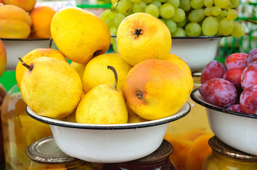 Farm market photo with ripe pear and other different fruits in white bowls - shallow depth of field.