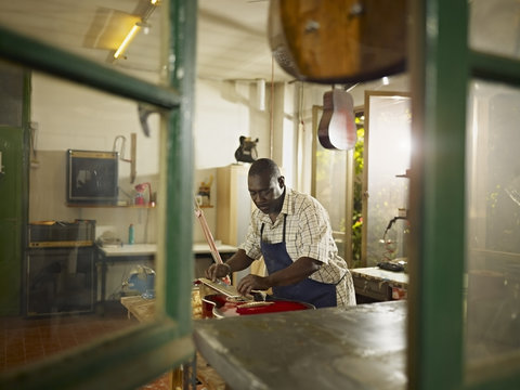 Luthier pitching guitar in his workshop
