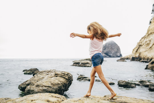 Girl Walking On Beach With Arms Stretched